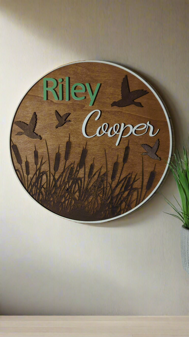 Birds and cattails round name sign